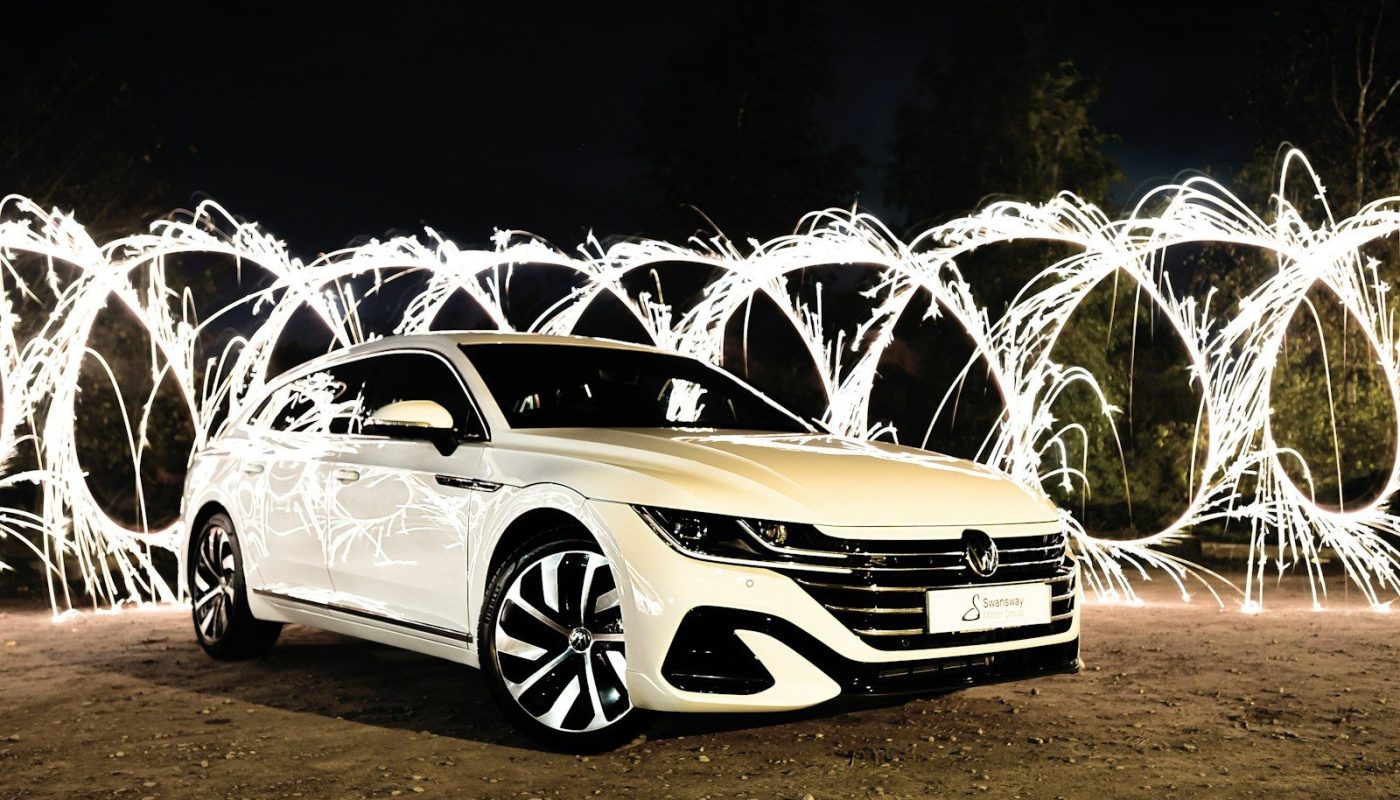 a car parked on a dirt road with fireworks in the background