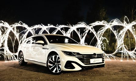 a car parked on a dirt road with fireworks in the background