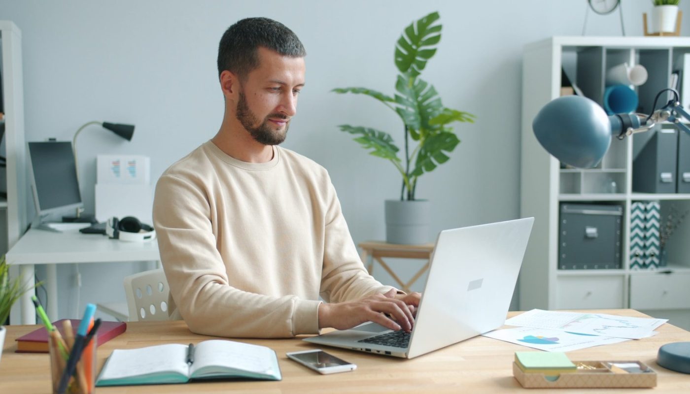Man working on laptop at a desk.