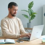 Man working on laptop at a desk.