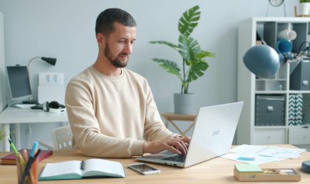 Man working on laptop at a desk.