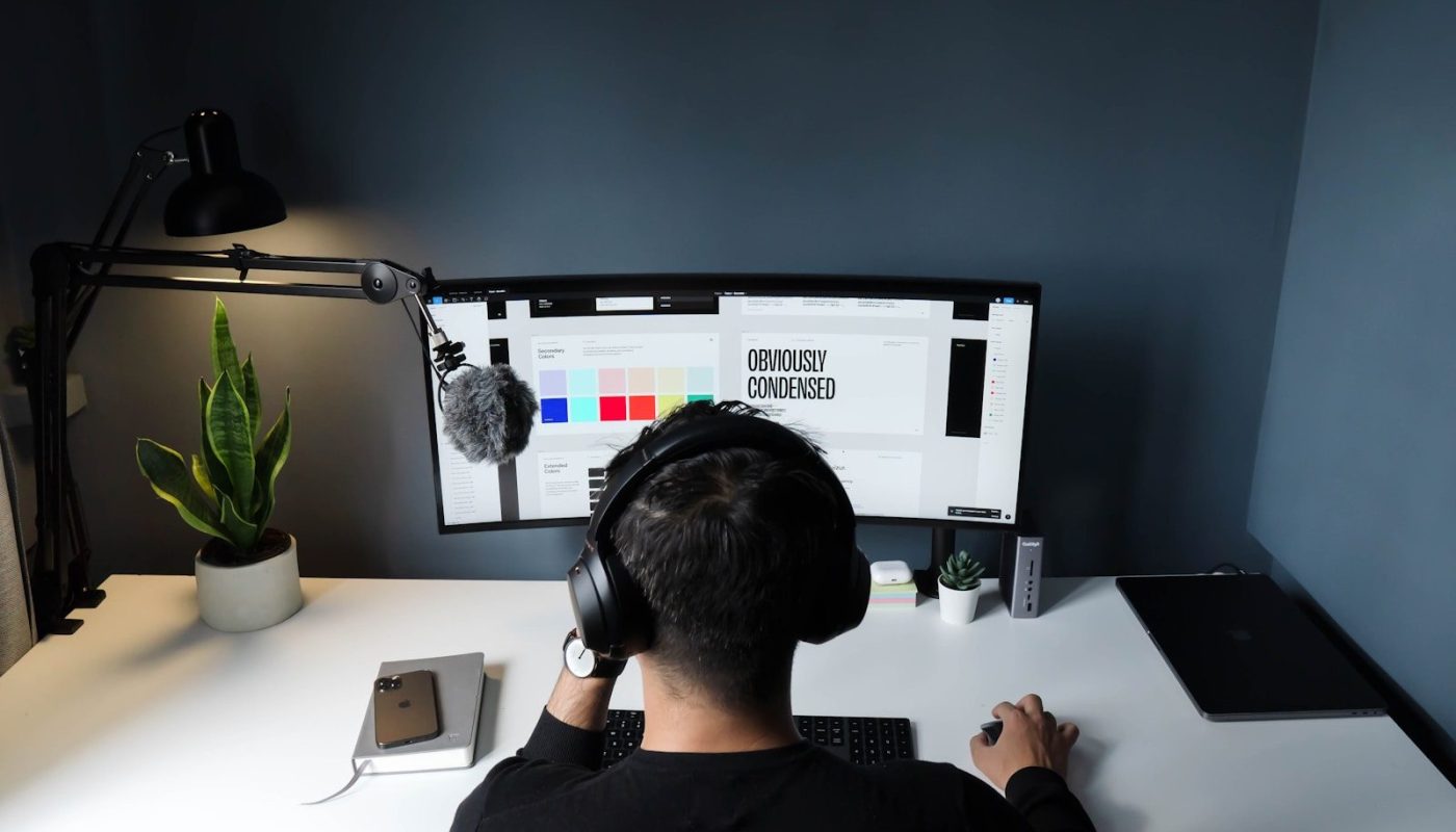 man in black shirt sitting in front of computer